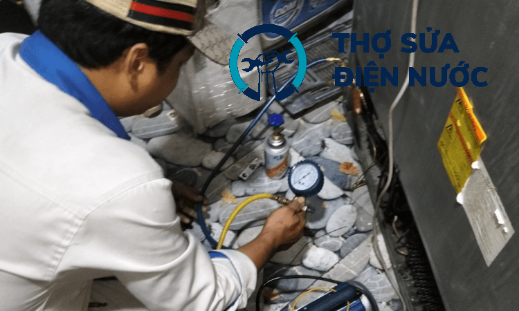 Thợ chuyên nghiệp đang đo áp suất gas tủ lạnh định kỳ